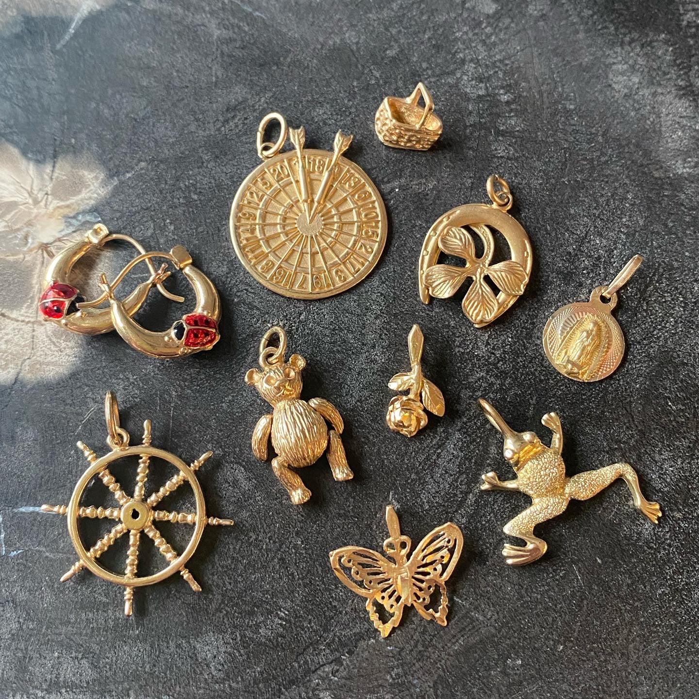 An assortment of vintage 14k gold charms and pendants
